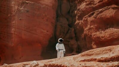 Photo d’une astronaute debout à côté d’une formation rocheuse pendant la journée. Illustration du chapitre 5 de l’émission : Une vie en anthroposophie, du podcast Méta de Choc. Ce chapitre s’intitule : La sortie du mouvement.