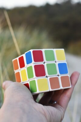 Photo d'un Rubik's Cube tenu dans une main. Illustration du chapitre 3 de l’émission : Émotion et rationalité, du podcast Méta de Choc. Ce chapitre s'intitule : Doit-on choisir entre rationalité et émotion ?