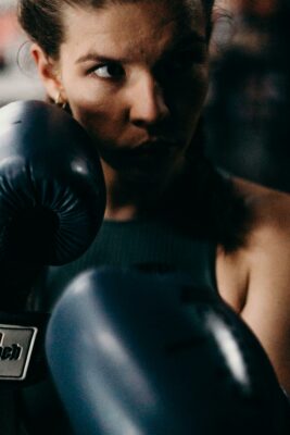 Photo d’un femme en train de boxer, le regard concentré. Illustration du chapitre 2 de l’émission : Reiki, tantra et emprise mentale, du podcast Méta de Choc. Ce chapitre s’intitule : Voyage au bout du New Age.