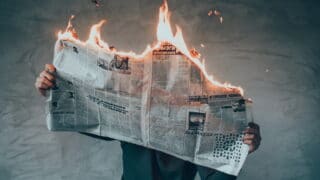 Illustration de l’émission SCOOP n°4, qui s’intitule : La vie devant nous. Il s’agit de la photo d’une personne cacher derrière le journal qu’elle lit. Le journal est en train de brûler par le haut.