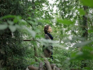 Illustration de l’émission STREAM n°9, qui s’intitule : Comment j’ai changé de paradigme. Il s’agit d’une photo d’Élisabeth Feytit dans une forêt, de profil, le regard qui observe loin devant.