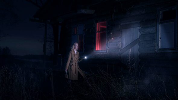 Une femme seule, de nuit, près d’une maison en bois. Elle tient une lampe torche et scrute les alentours, évoquant une scène d’enquête. Illustration du Shocking intitulé « Détective privée : en quête de vérité », du podcast Méta de Choc.