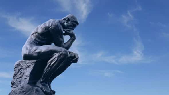 Sculpture du Penseur d'Auguste Rodin. La statut représente une réflexion profonde. En arrière-plan on peut voir un ciel bleu clair. Illustration du teaser de l’émission SHOCKING intitulée : L’esprit critique, ça s’apprend ? du podcast Méta de Choc.